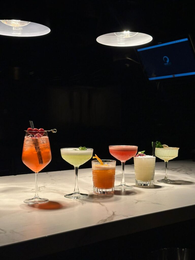 Verschillende cocktails op een rij aan de bar van Papa Ito